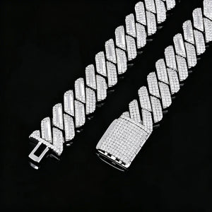 Flat lay studio product shot of 19mm full iced out prong set rectangular baguette cuban link chain for men, polished 18K white gold plated solid copper base, two chain ends displayed side by side showing empty insertion clasp and fully micro pave diamond covered box clasp, every link hand-set with flawless VVS grade simulated diamond stones, laid flat on glossy black reflective mirror board with natural soft mirror reflection, heavy thick hip hop street bling statement jewelry close-up detail photo RDRIP