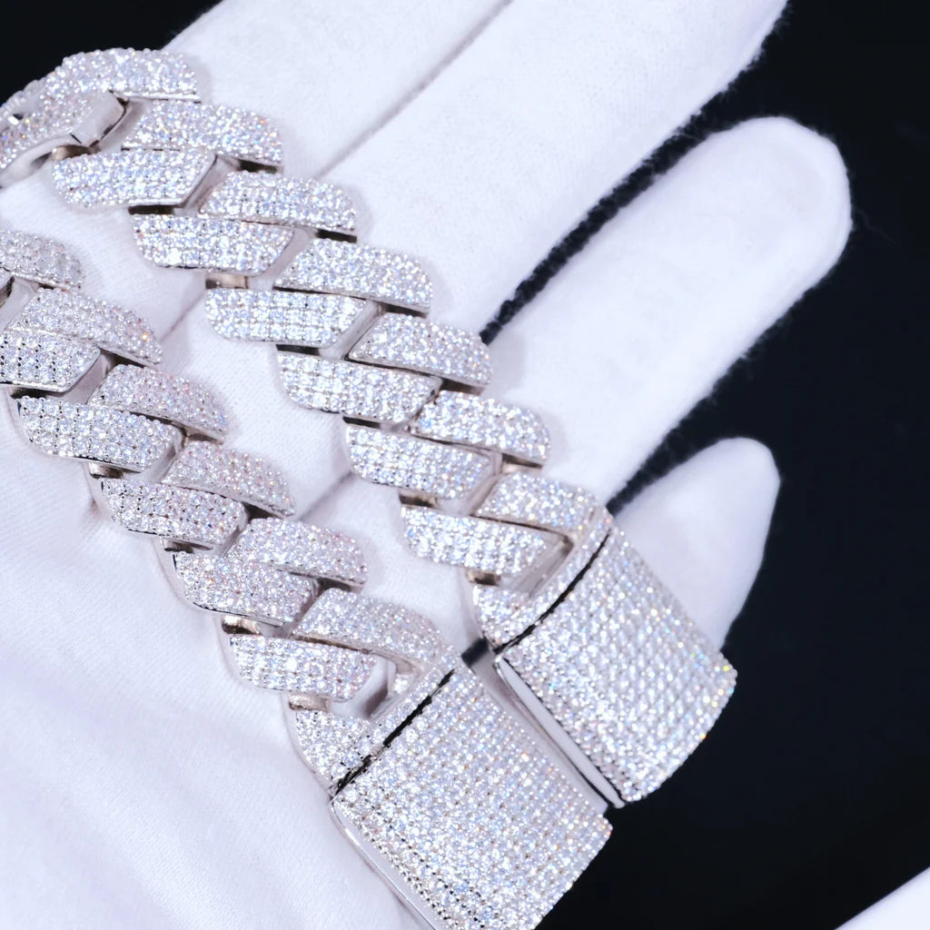 Extreme close-up macro shot of 19mm full iced out prong cuban link bracelet laid on clean white jewelry cotton gloves, fully pavé encrusted flawless lab tested VVS simulated diamonds covering every link and wide box clasp, premium hand-set prong lifting craftsmanship, durable solid copper base with shiny 18K white gold plating, heavy thick unisex hip hop bling wrist chain with brilliant icy sparkle, tarnish resistant luxury streetwear jewelry for men and women RDRIP JEWELRY
