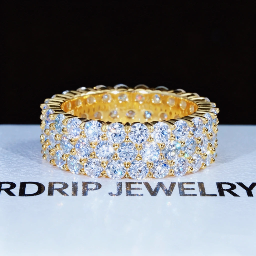 18K gold plated 925 sterling silver 8 millimeter wide 3 row cluster moissanite eternity ring displayed on branded white RDRIP JEWELRY surface, hand set D‑color VVS1 plus 4mm round hearts and arrows moissanite gemstones, iced out full‑band hip hop unisex ring, high sparkle bling jewelry, GRA certified moissanite passes most diamond testers, premium fashion statement ring for men women RDRIP JEWELRY
