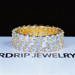 18K gold plated 925 sterling silver 8 millimeter wide 3 row cluster moissanite eternity ring displayed on branded white RDRIP JEWELRY surface, hand set D‑color VVS1 plus 4mm round hearts and arrows moissanite gemstones, iced out full‑band hip hop unisex ring, high sparkle bling jewelry, GRA certified moissanite passes most diamond testers, premium fashion statement ring for men women RDRIP JEWELRY

