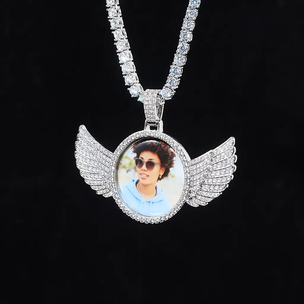 Suspended hanging white gold 3D Angle Wing Custom Picture Pendant personalized photo hip hop necklace paired with full iced tennis chain hanging against black background by RDRIP Jewelry