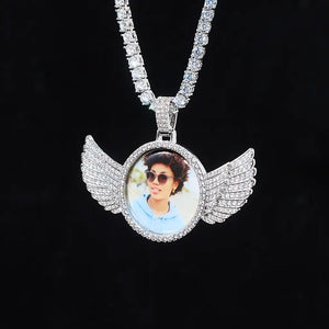 Suspended hanging white gold 3D Angle Wing Custom Picture Pendant personalized photo hip hop necklace paired with full iced tennis chain hanging against black background by RDRIP Jewelry