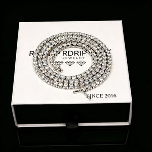 3MM iced‑out single‑row tennis‑chain necklace coiled neatly on branded white gift box, prong‑set VVS grade CZ simulated diamonds, brilliant bling shine, unisex hip‑hop fashion jewelry for men women, premium gift‑ready packaging, RDRIP JEWELRY

