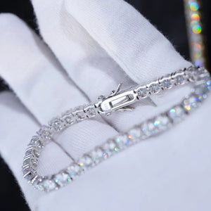 Extreme macro close-up shot focusing on double safety clasp stamped S925 of 4mm D Color VVS1 moissanite tennis bracelet, solid S925 sterling silver base coated with thick 18K white gold plating, every round moissanite stone hand prong-set with dazzling rainbow light reflection, bracelet laid gently on soft clean white cotton jewelry gloves, dark blurred background to highlight metal texture and crystal fire, reinforced dual lock clasp prevents accidental falling off, unisex icy hip hop stackable wrist jewel