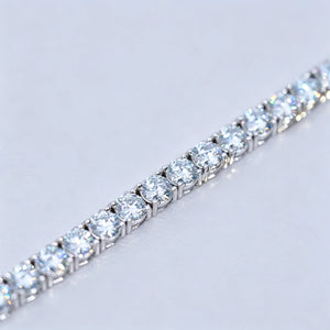 Ultra detailed macro close-up shot showcasing row of 4mm ideal Hearts & Arrows cut D Color VVS1+ clarity moissanite stones on unisex tennis bracelet, solid genuine S925 sterling silver base wrapped in thick premium 18K white gold plating, each colorless flawless moissanite gem individually hand prong-set by professional jewelry artisans, intense rainbow fire light refraction and bright icy sparkle on every round stone, bracelet laid flat on smooth clean plain white background with all golden text logos and 