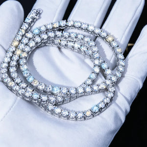 4MM VVS1 D‑Color Moissanite Tennis Chain coiled and stacked, held in clean white jewelry inspection gloves, 925 Sterling Silver White Gold Plated, ideal hearts and arrows cut moissanite stones with brilliant fire and sparkle, dark studio background, premium iced‑out hip hop necklace close‑up shot RDRIP JEWELRY
