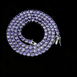 4mm Aurora Rainbow Iced Tennis Chain coiled overhead view, deep purple pastel ombré gradient round VVS CZ simulated diamonds, hand prong‑set stones, sturdy metal lock clasp detail, brilliant sparkling starburst shine, 18K gold plated unisex hip hop bling necklace on solid black studio background, RDRIP JEWELRY
