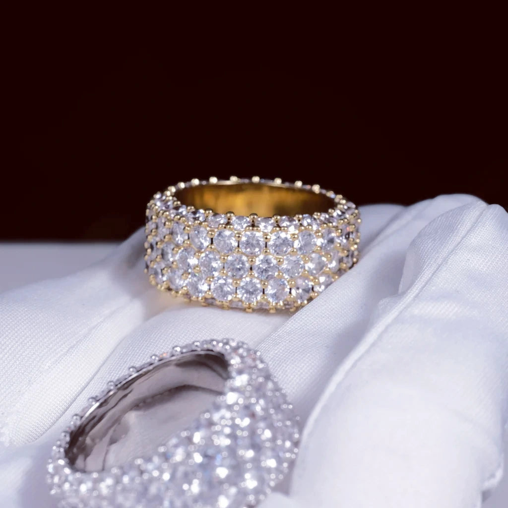 RDRIP JEWELRY 5‑Row Fully Paved Iced Out Eternity Ring gold‑toned and silver‑toned two rings laid on premium white cotton glove, deep dark burgundy bokeh background, heavy 14mm wide prong‑set hip hop eternity band, full‑around meticulously hand‑set flawless VVS simulated diamonds, stunning multi‑faceted light reflection, premium 18K & white gold plated icy bling jewelry for men and women, Prong Cuban family wide statement hip‑hop ring
