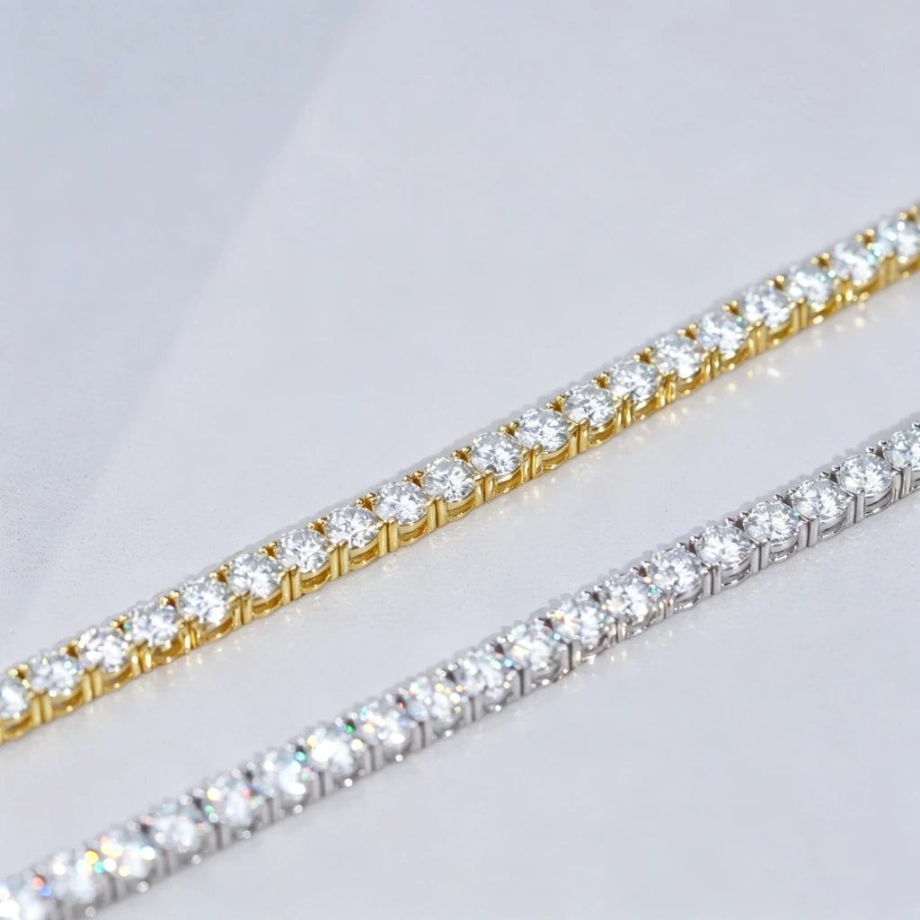 Side-by-side comparison macro shot of two 5mm D Color VVS1+ Hearts & Arrows cut moissanite tennis chains, one finished with thick 18K yellow gold plating and the other polished silver plating, both crafted on solid genuine S925 sterling silver base, every clear flawless moissanite stone precisely hand prong-set by professional jewelry artisans, striking rainbow light sparkle and bright crystal luster on each round gemstone, dual wrist chains laid parallel diagonally on smooth clean plain light grey