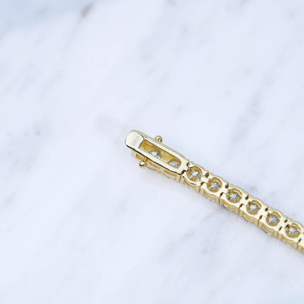 RDRIP JEWELRY close‑up macro photo of 5MM moissanite tennis chain box clasp, engraved S925 sterling silver marking on gold plated safety lock, inner side view showing hand‑set round moissanite stones, secure double safety locking mechanism, hip hop bling necklace hardware detail shot, genuine 925 silver stamp, premium men women unisex tennis chain jewelry, marble soft background studio detail photography

