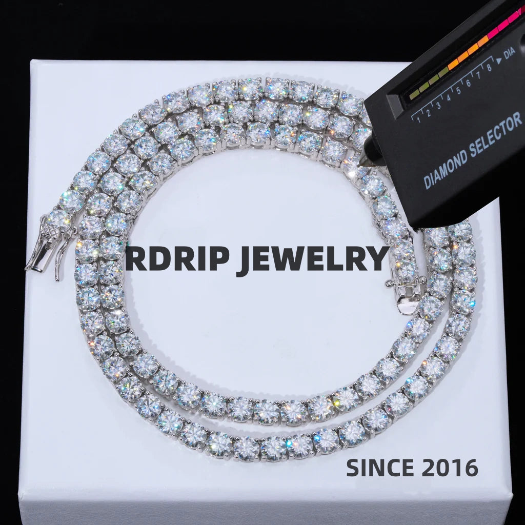 5MM round brilliant VVS1 D color moissanite tennis chain necklace made of solid S925 sterling silver with white gold plating, lab moissanite stone passes professional diamond selector tester, ultra sparkly icy hand-set moissanite stones with strong star fire shine, anti-tarnish unisex hip hop iced out tennis chain jewelry, laid flat on clean plain white luxury gift box background, no distracting text, brilliant stone luster and bright chain finish preserved, premium streetwear bling accessory for men women 