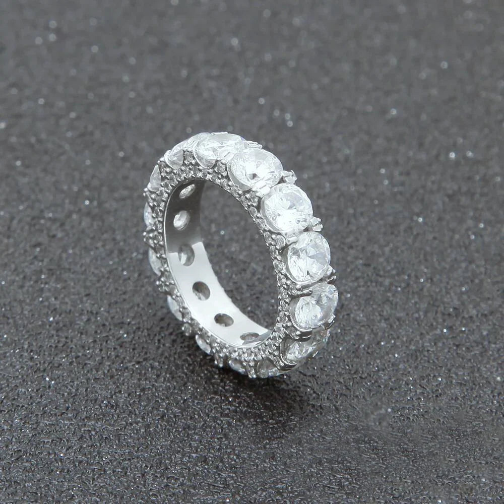close‑up view of silver plated 5mm iced out round full eternity ring bold prong set aaa cubic zirconia full band ring side micro pave icy details hip hop unisex statement ring dark speckled textured background RDRIP JEWELRY
