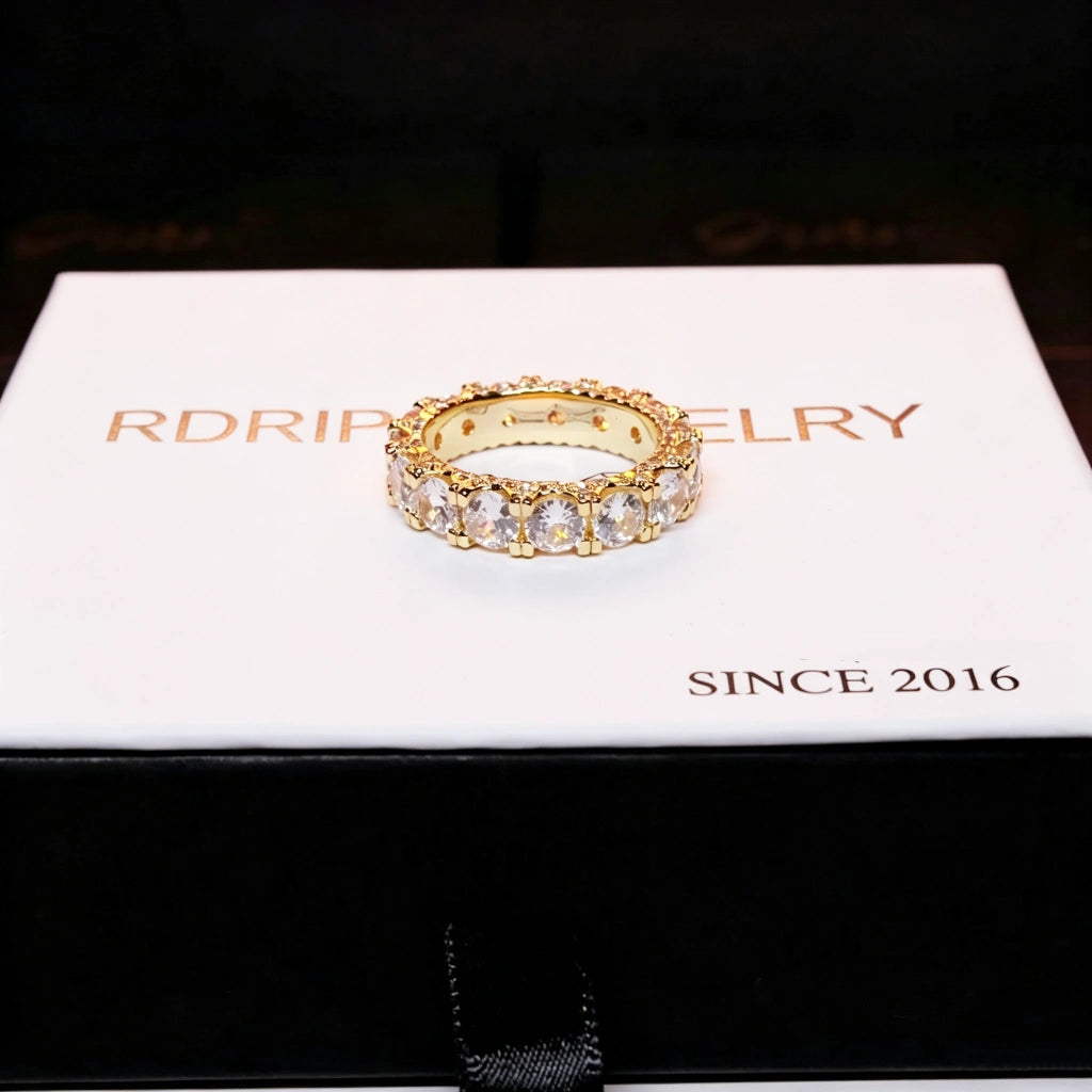 top view shot of 18k gold plated 5mm iced out round full eternity ring bold prong set aaa cubic zirconia full band ring placed on clean white branded gift box hip hop unisex icy ring stacking jewelry RDRIP JEWELRY
