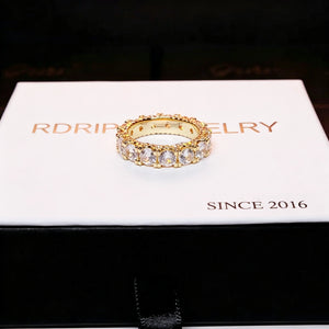 top view shot of 18k gold plated 5mm iced out round full eternity ring bold prong set aaa cubic zirconia full band ring placed on clean white branded gift box hip hop unisex icy ring stacking jewelry RDRIP JEWELRY
