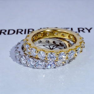 6.00 CARAT S925 VVS1+ moissanite single‑row full eternity ring, 4mm round ideal cut hearts and arrows moissanite stones, stacked display of 18K gold‑plated and white gold‑plated genuine 925 sterling silver bands, brilliant icy sparkling full circle band rings, overhead close‑up shot laid on RDRIP JEWELRY branded white surface, unisex hip‑hop wedding stackable matching fine bling jewelry product photograph RDRIP JEWELRY