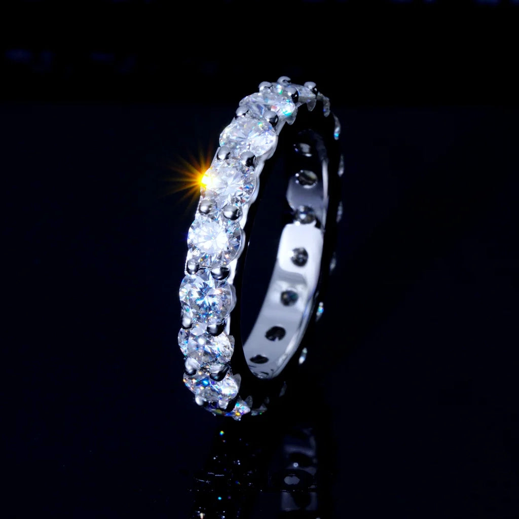 6.00 CARAT S925 VVS1+ moissanite single‑row full eternity ring 4mm round ideal cut hearts and arrows stones, white gold plated genuine 925 sterling silver band, brilliant moissanite stones with sparkle star light flare effect, close‑up side view shot, icy full circle band ring for hip‑hop wedding stacking, unisex luxury bling fine jewelry dark background product photography RDRIP JEWELRY