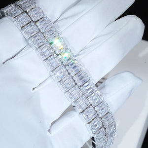 Angled shot of 8mm  width iced baguette cluster tennis bracelet resting on white cotton glove, flawless VVS simulated baguette cluster diamonds with bright rainbow‑colored light reflection and sparkling starburst glints, white gold plated copper hip hop bling wrist bracelet, unisex luxury iced‑out hip‑hop jewelry for men women RDRIP JEWELRY
