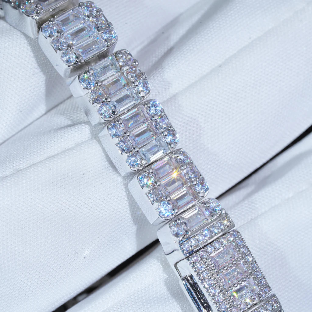 Close‑up macro shot of 8mm 9.5mm width iced baguette cluster tennis bracelet, hand‑set flawless VVS simulated baguette and round diamonds, white gold plated copper hip hop bling bracelet, intricate stone cluster details on white fabric background, premium iced out hip‑hop jewelry for men women RDRIP JEWELRY
