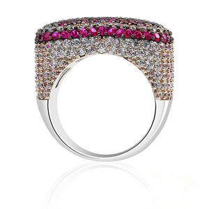 Back‑view studio shot showing inner band and back setting of magenta pink iced out pave love heart ring, full micro hand‑set AAA cubic zirconia stones with magenta pink top border, polished smooth metal ring shank, dense multi‑layer stone pave craftsmanship, subtle reflection on clean white background, heavy wide unisex hip hop bling statement rapper jewelry for men women RDRIP JEWELRY
