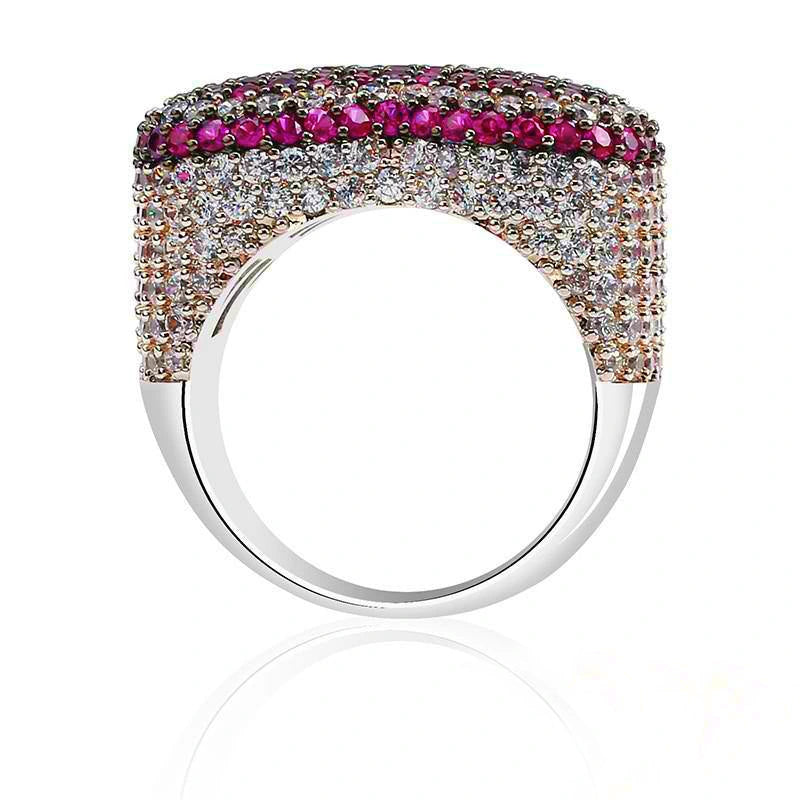 Back‑view studio shot showing inner band and back setting of magenta pink iced out pave love heart ring, full micro hand‑set AAA cubic zirconia stones with magenta pink top border, polished smooth metal ring shank, dense multi‑layer stone pave craftsmanship, subtle reflection on clean white background, heavy wide unisex hip hop bling statement rapper jewelry for men women RDRIP JEWELRY
