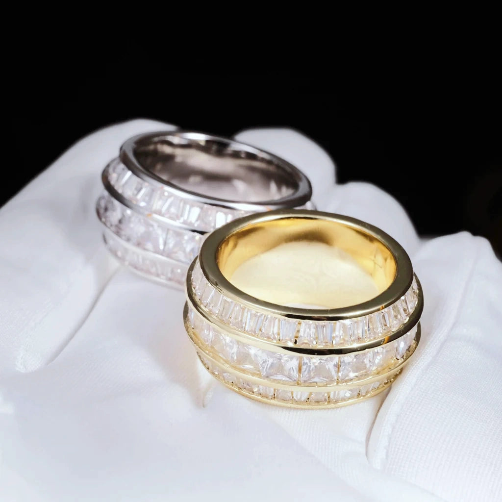 Overhead view showing gold plated and white gold plated Baguette Square Triple Row Rings laid on white microfiber glove, 12mm wide men hip hop band rings, hand set flawless VVS simulated baguette and square cut stones full pave heavy icy bling mens statement jewelry two color options showcase RDRIP JEWELRY
