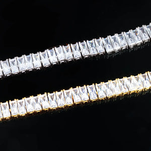 Blaze Retro Baguette‑Cut Iced Tennis Bracelet macro close‑up detail shot, side‑by‑side 18k gold plated and silver‑toned tennis bracelet, hand‑set rectangular baguette‑cut AAA cubic zirconia stones, prong setting hip hop bling jewelry, high clarity simulated diamond stones on black background showing stone brilliance and prong craftsmanship RDRIP JEWELRY
