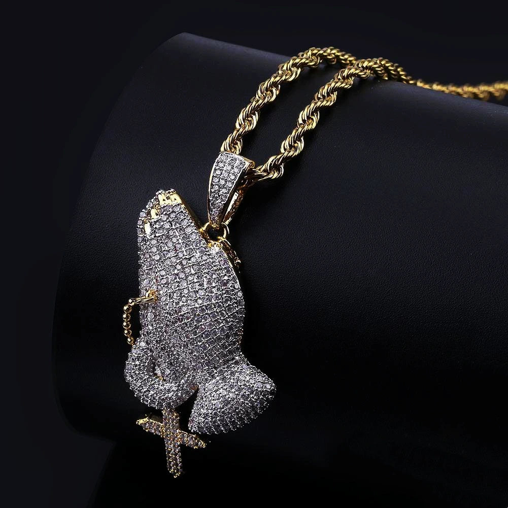 Back side view of iced two tone blessing praying hands pendant with dangling cross charm, fully paved flawless VVS simulated diamonds, copper 18k gold plated hip hop men faith bling jewelry displayed on black leather stand RDRIP JEWELRY
