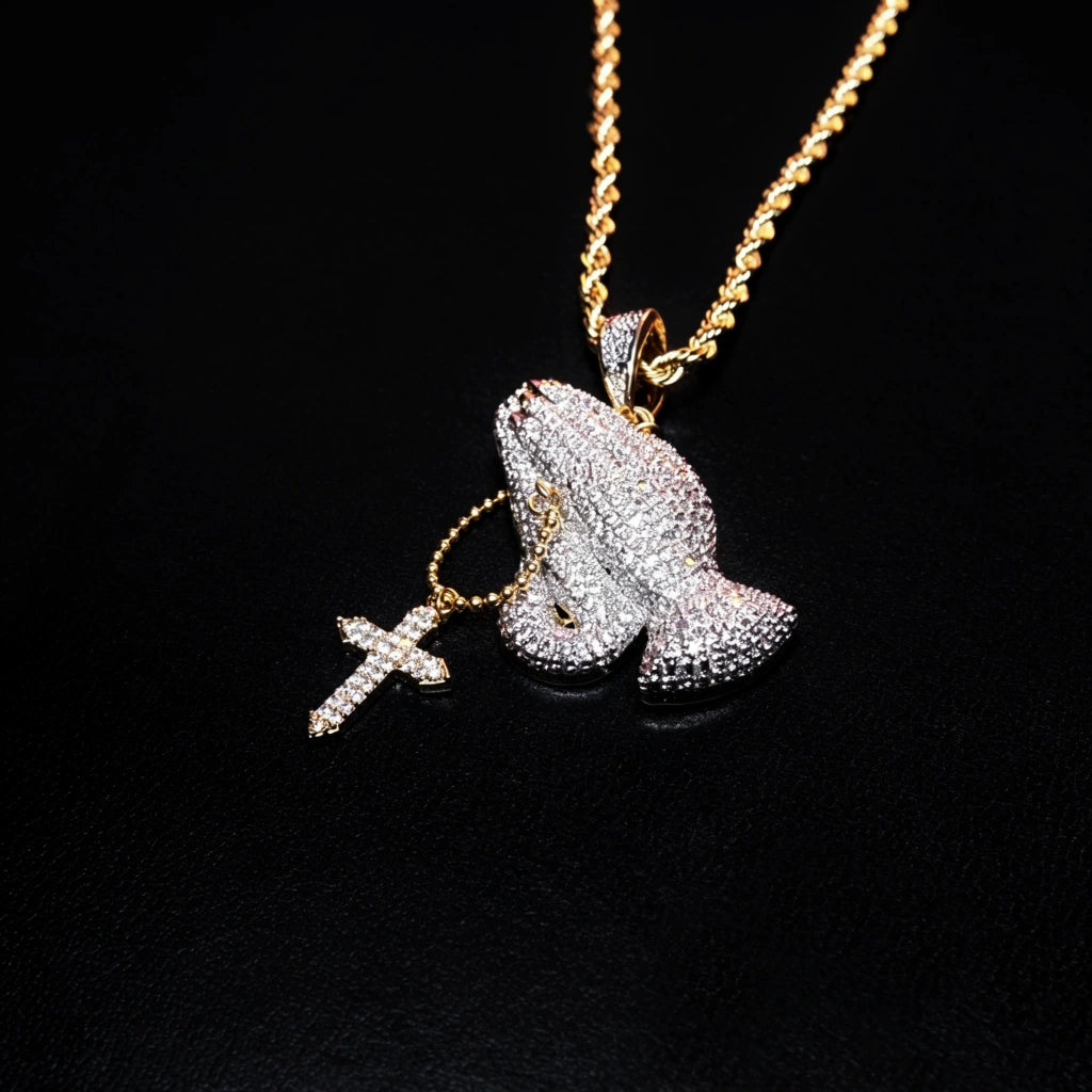 Close up view of iced two tone blessing praying hands pendant with dangling cross charm, fully encrusted flawless VVS simulated diamonds, copper 18k gold plated men faith hip hop bling jewelry on pure black background RDRIP JEWELRY
