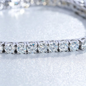 Close-up studio product shot of a straight row S925 sterling silver moissanite tennis bracelet, featuring round brilliant cut VVS1 D color moissanite stones secured by individual prong settings, clear stone facets, bright white and silver light reflection, clean polished metal finish, elegant white bokeh background, luxury hip hop bling wrist chain for men and women, premium lab created moissanite jewelry, hand set stones, comfortable daily wear bracelet, party and streetwear accessory, high sparkle fine