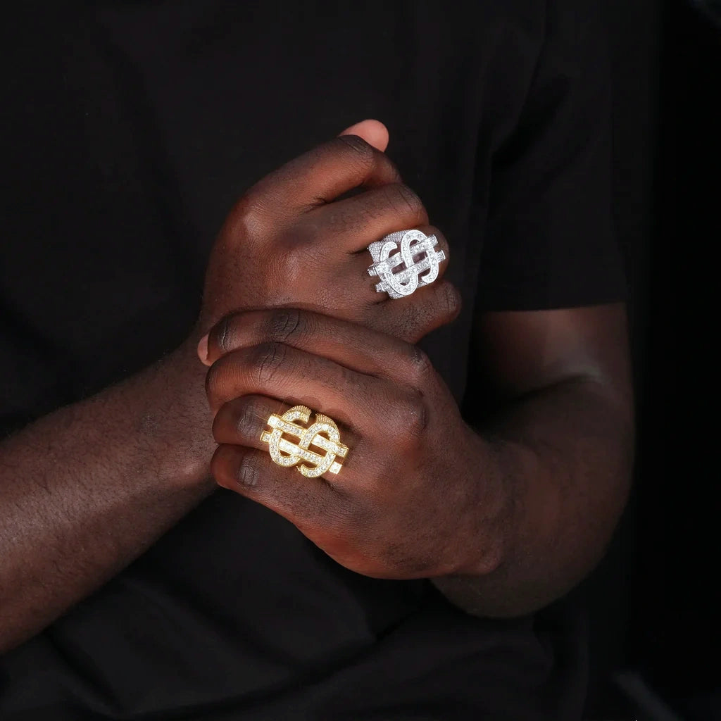 RDRIP JEWELRY Dollar Tycoon hollow double US dollar sign ring, gold plated and silver tone two color version worn on male model hands, interlocked dollar symbol iced out AAA cubic zirconia hip hop men ring, real wear lifestyle shot against dark background
