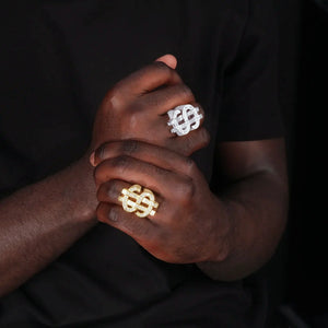 RDRIP JEWELRY Dollar Tycoon hollow double US dollar sign ring, gold plated and silver tone two color version worn on male model hands, interlocked dollar symbol iced out AAA cubic zirconia hip hop men ring, real wear lifestyle shot against dark background
