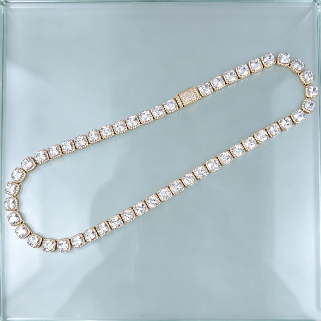 Top‑down flat lay product photograph showing full length of 10MM Glacier Cushion Clustered Tennis Chain in 18K Gold, complete iced‑out hip hop tennis necklace with fully paved diamond lock clasp, hand‑set flawless VVS cushion cut simulated cluster diamonds with bright sparkling reflections, laid flat on seamless clear transparent glass surface, luxury unisex streetwear bling statement jewelry RDRIP JEWELRY
