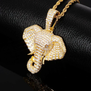 Close up view of 18k gold plated iced micro paved pharaoh elephant head pendant, densely encrusted with AAA cubic zirconia stones, matched with gold rope chain, placed on textured black leather with mirror reflection effect, shiny hip hop statement charm necklace for men RDRIP JEWELRY
