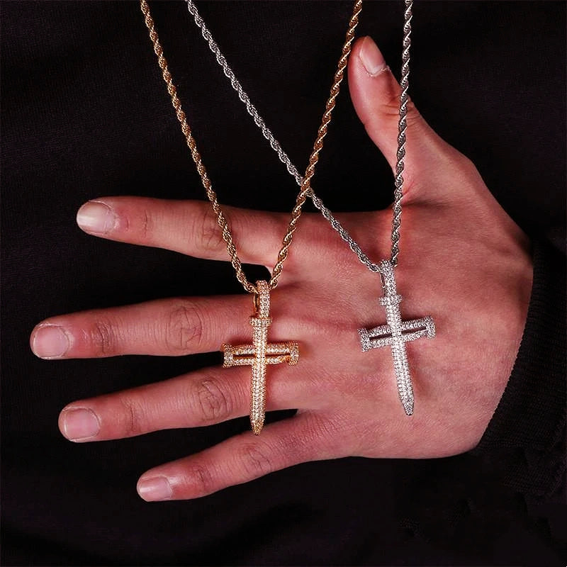 Hand held size reference shot of Iced Out Nail Cross Pendant, 18k gold plated and silver tone full pave AAA cubic zirconia nail crucifix necklaces with rope chain for men, showing real product dimension against dark fabric background RDRIP JEWELRY
