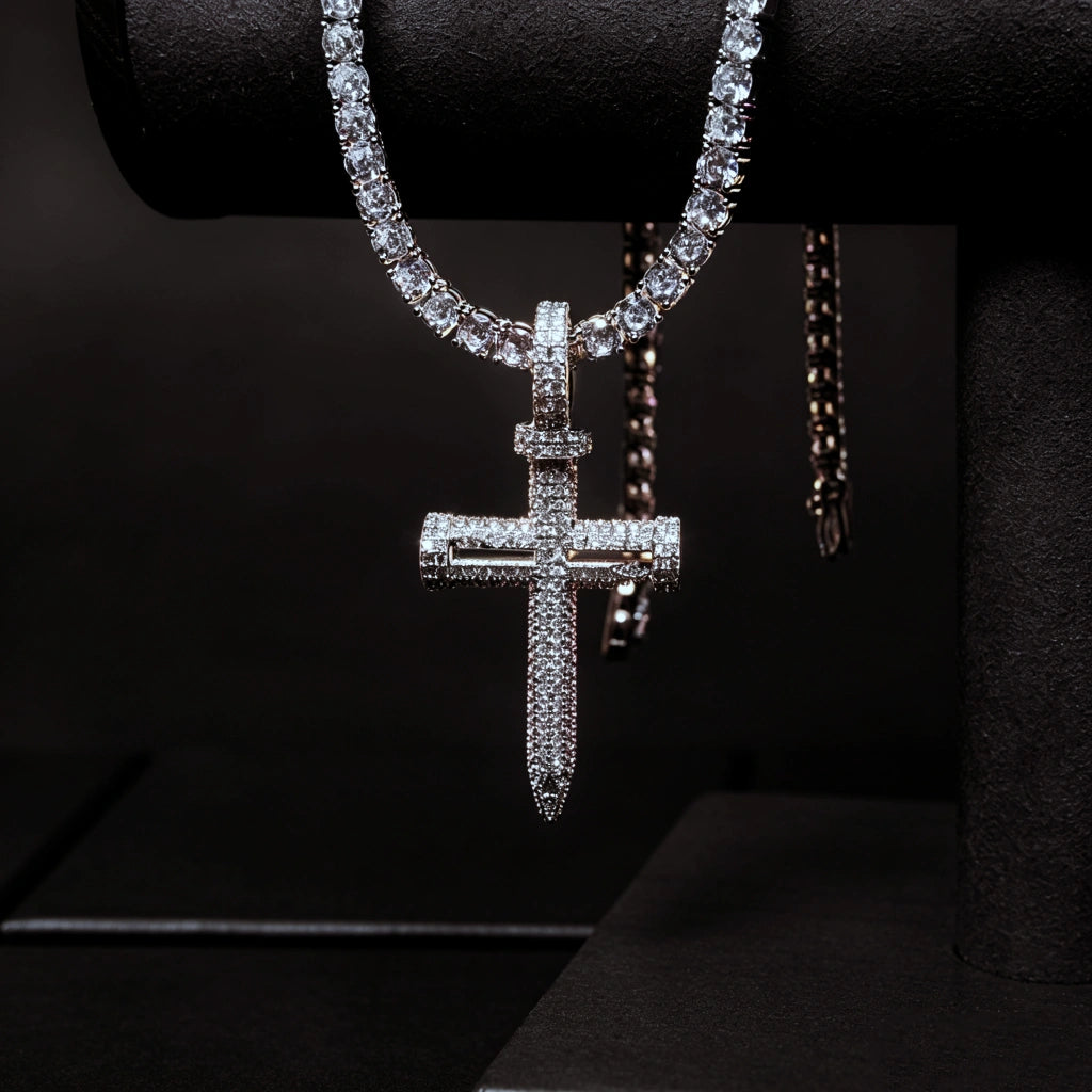 Hanging displayed Iced Out Nail Cross Pendant full pave AAA cubic zirconia silver tone nail crucifix necklace for men, premium bling hip hop street jewelry paired with tennis chain against deep pure black background RDRIP JEWELRY
