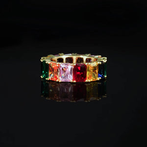 RDRIP JEWELRY Iced Out Rainbow Baguette Eternity Ring gold plated front close up product photo vivid multicolor baguette cut cubic zirconia stones prong set full band hip hop bling ring displayed on black glossy reflective surface unisex fashion statement jewelry
