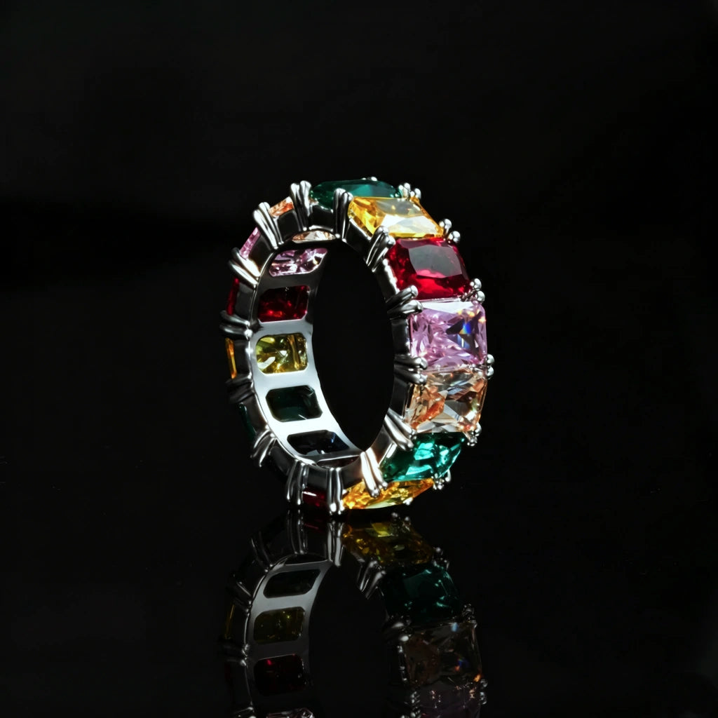 RDRIP JEWELRY Iced Out Rainbow Baguette Eternity Ring silver tone full band ring multicolor baguette cut cubic zirconia hip hop jewelry product photograph on black glossy reflective background showing inner band and stone setting detail for men women bling statement accessory
