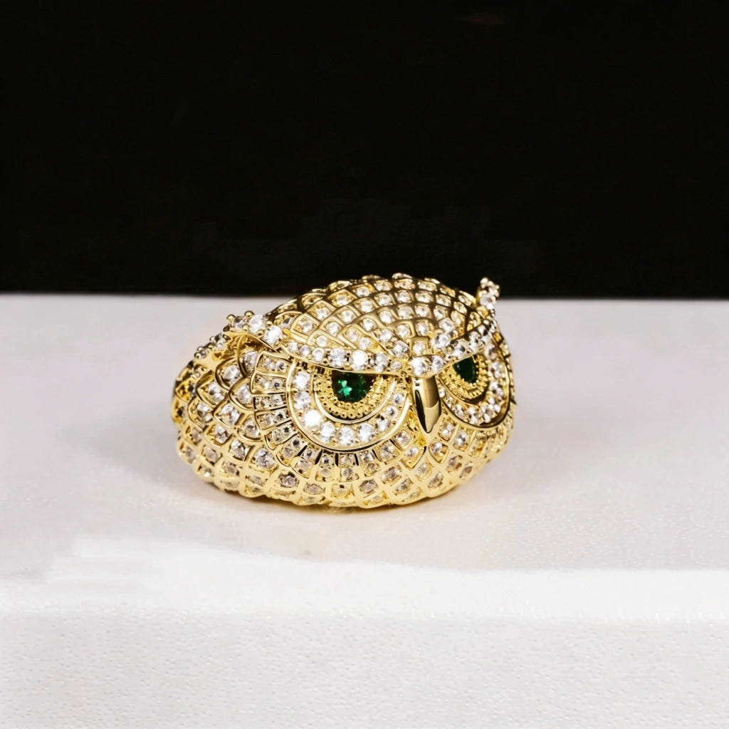 Studio shot of single 18K gold plated Iced Owl King Ring, intricate owl scale texture, striking emerald green eyes, full micro‑paved flawless VVS simulated diamonds, heavy iced out hip hop mens statement ring on clean white display surface RDRIP JEWELRY
