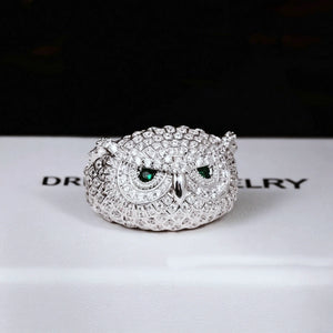 Close‑up studio photo of single white gold plated Iced Owl King Ring, detailed owl scale texture, vivid emerald green eyes, fully micro‑paved flawless VVS simulated diamonds, heavy weight iced out hip hop mens ring displayed on RDRIP JEWELRY branded box RDRIP JEWELRY
