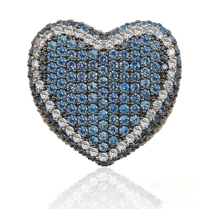 Macro close‑up studio shot of icy blue iced out pave love heart ring, densely hand‑set AAA cubic zirconia blue gemstones framed by sparkling clear CZ border, full micro pave heart‑shaped hip hop bling statement ring, subtle soft reflection on clean isolated white background, heavy unisex street rapper fashion jewelry for men and women RDRIP JEWELRY
