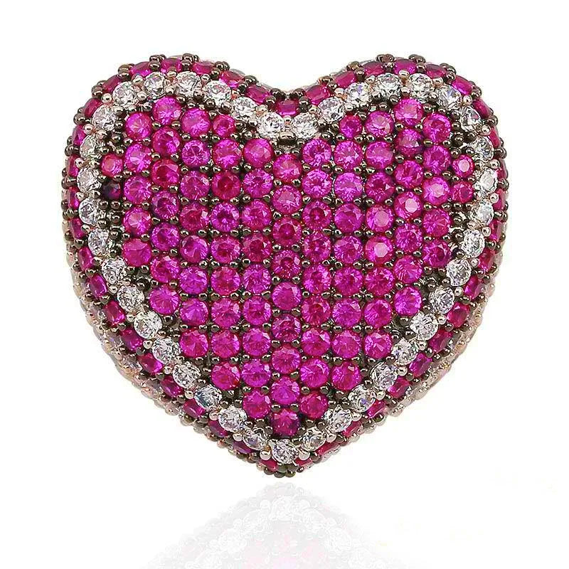 Macro close‑up view of magenta pink iced out pave love heart ring, densely hand‑set AAA cubic zirconia stones with sparkling clear CZ border detail, full micro pave heart‑shaped hip hop bling ring, thick statement ring surface, isolated clean white background, unisex luxury street wear rapper jewelry for men women RDRIP JEWELRY
