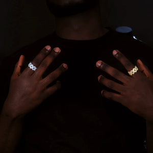 Black male model wearing rhodium plated and 18k gold plated Iced Out 2‑Row Micro‑Paved AAA CZ Miami Cuban Lock Ring, two finish comparison lifestyle shot, mens hip hop bling statement jewelry RDRIP JEWELRY
