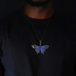 Micro‑pave iced out blue black butterfly pendant necklace black gunmetal finish worn on model paired with black rope chain sparkling flawless VVS simulated diamonds dark background hip hop street fashion wearing shot RDRIP JEWELRY
