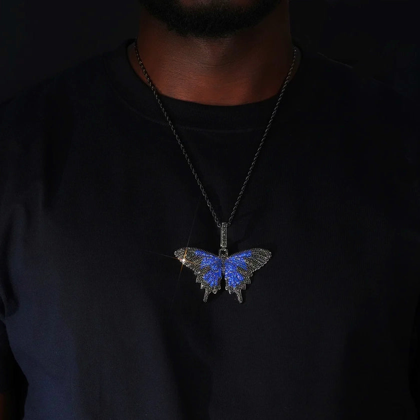 Micro‑pave iced out blue black butterfly pendant necklace black gunmetal finish worn on model paired with black rope chain sparkling flawless VVS simulated diamonds dark background hip hop street fashion wearing shot RDRIP JEWELRY
