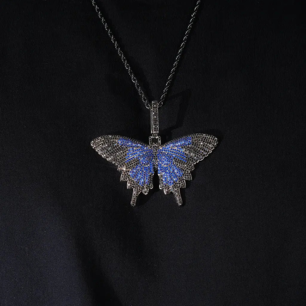 Micro‑pave iced out blue black butterfly pendant necklace black gunmetal finish matched with black rope chain full paved flawless VVS simulated diamonds hip hop bling jewelry flat lay studio photo RDRIP JEWELRY
