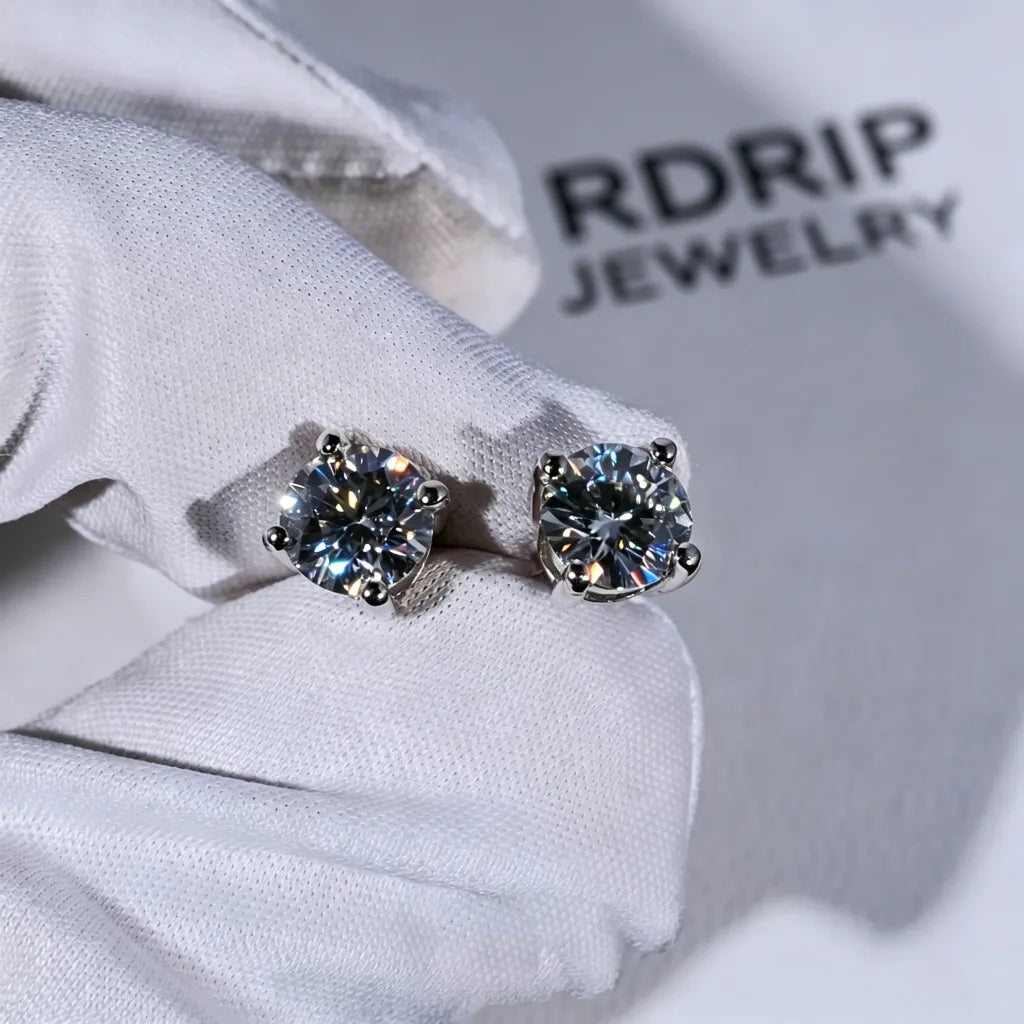 Minimalist Solitaire Round Moissanite Stud Earrings, 4-prong VVS1 hearts and arrows round moissanite studs, 925 sterling silver white gold plated unisex hip hop earrings, closeup photo held on white jewelry glove with branded backdrop RDRIP JEWELRY
