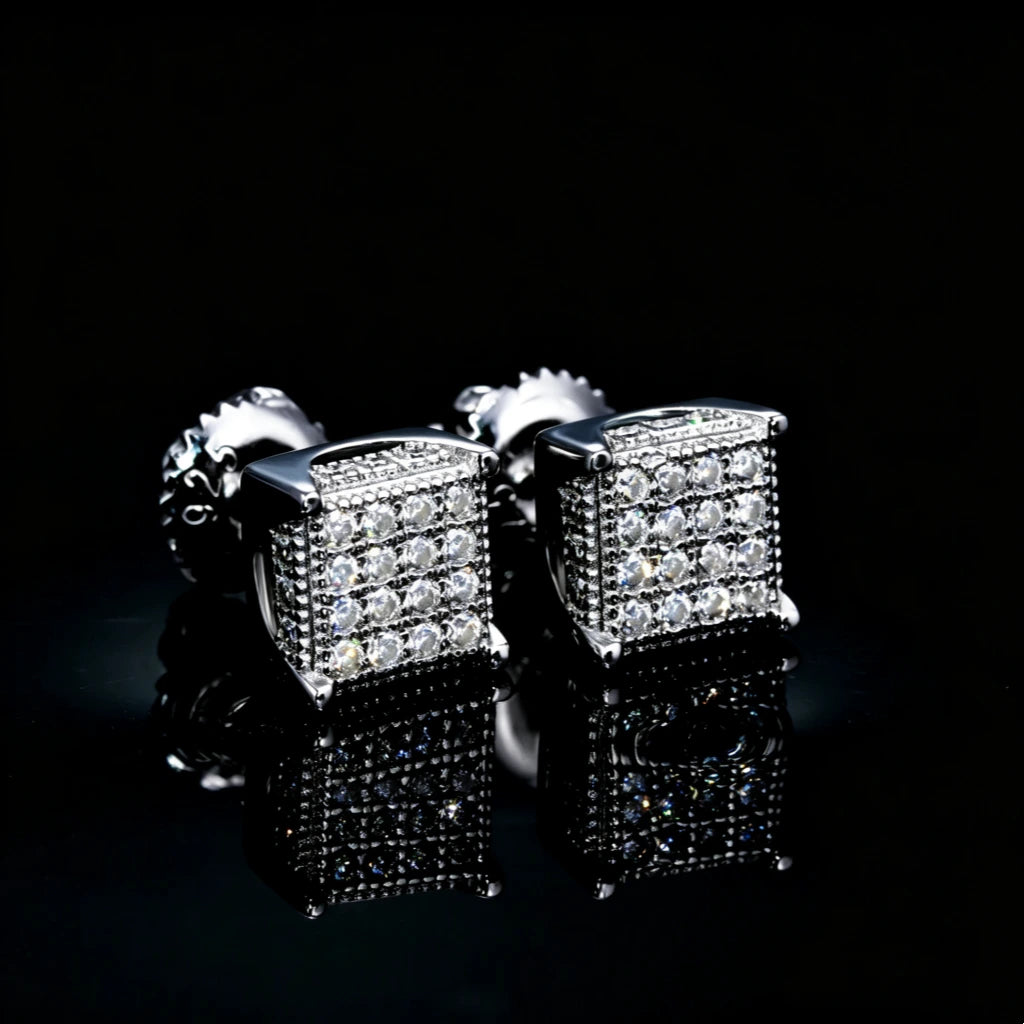 S925 Silver VVS Moissanite Micro Pave Border Cube Stud Earrings, paired front view of 3D fully iced cube earrings with screw back, hip hop square stud jewelry on reflective black surface, RDRIP JEWELRY
