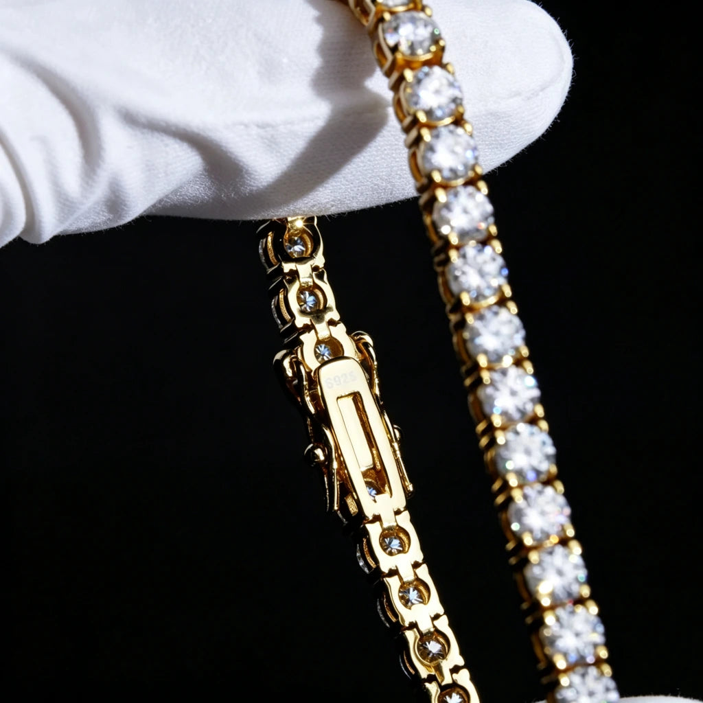 Extreme macro closeup shot of S925 sterling silver 18K gold plated 4MM round VVS1 D color moissanite tennis bracelet, detailed double safety lock clasp engraved S925 stamp, held by clean white jewelry gloves on solid pure black background, clear close view of hand-set sparkling moissanite stones with brilliant rainbow fire shine, unisex hip hop iced out luxury wrist chain for men women, stackable streetwear bling jewelry, durable anti-tarnish gold finish, 7in 8in size options, RDRIP JEWELRY established 2016