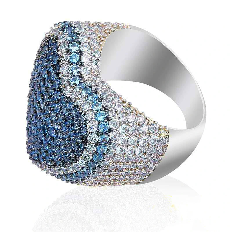 Side‑angle studio shot of icy blue iced out pave love heart ring, polished smooth thick inner metal band, gradient blue‑grey and clear hand‑set AAA cubic zirconia full micro pave detailing, heavy wide hip hop bling heart statement ring, soft subtle reflection on clean isolated white background, unisex rapper street fashion luxury jewelry for men and women RDRIP JEWELRY
