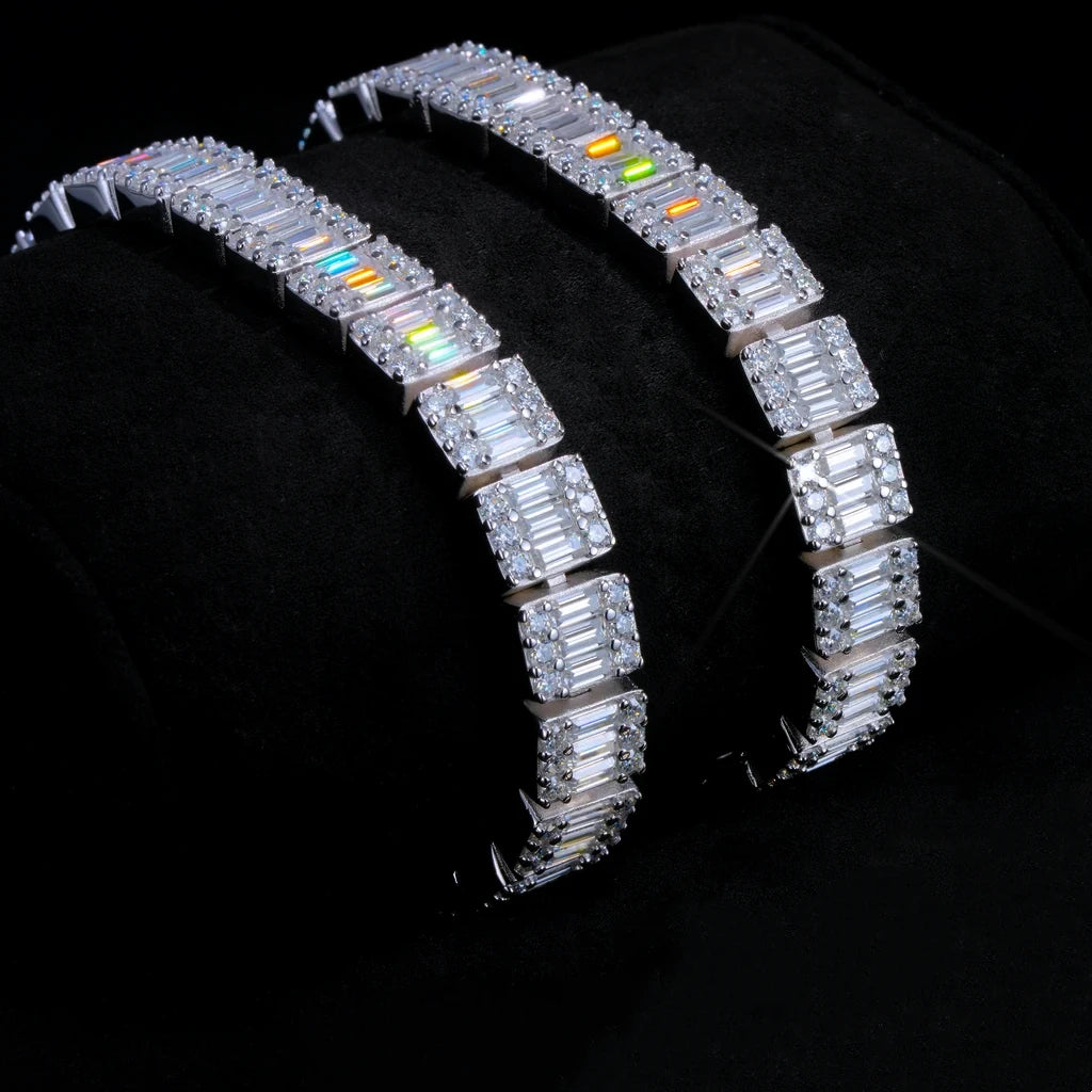 Slanted studio display shot of two 8mm rectangular baguette cut VVS1+ D color moissanite tennis bracelets resting on soft black velvet cushion, crafted from solid S925 sterling silver with dual plating options of polished white gold and 18K gold, every rectangular baguette moissanite surrounded by round brilliant moissanite hand prong set by skilled artisans, brilliant rainbow light fire and icy diamond-like sparkle, scratch and tarnish resistant daily wear hip hop street stacking wrist jewelry for men